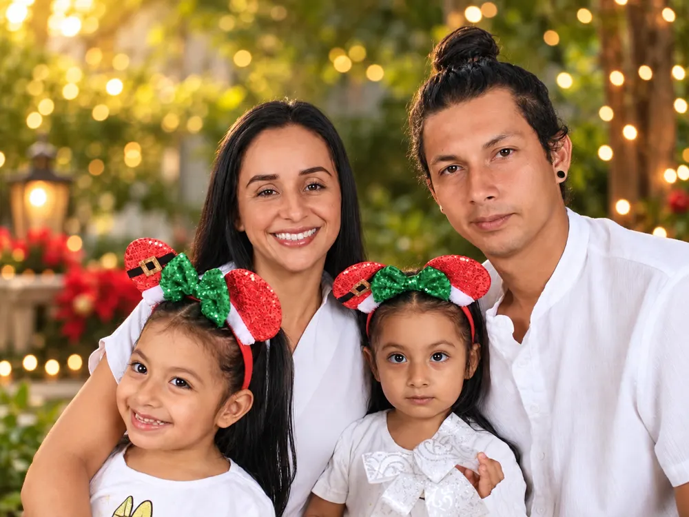 Laura Delgado y su esposo Rigoberto Pereira con sus hijas, en un jardín con luces navideñas