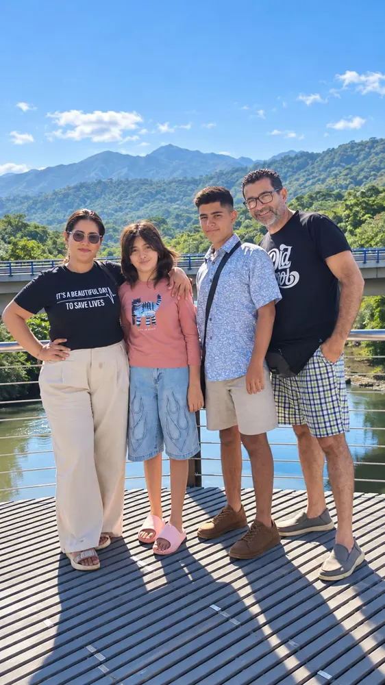 El pastor Juan José Venegas y su esposa Kimberly con sus hijas, en un mirador con montañas de fondo